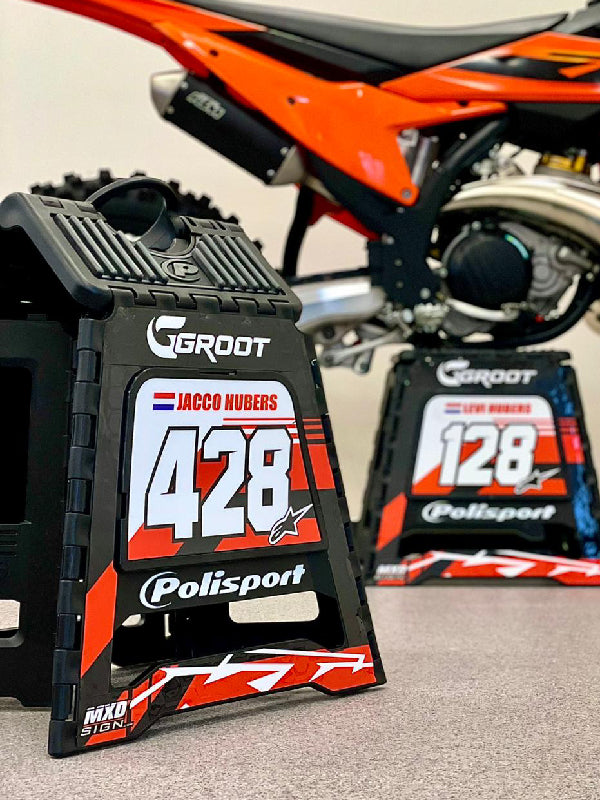 Twee Polisport opvouwbare motorsteunen met een persoonlijk stickerst in het oranje met wit. De stickers zijn inclusief naam en nummer van de rijders.